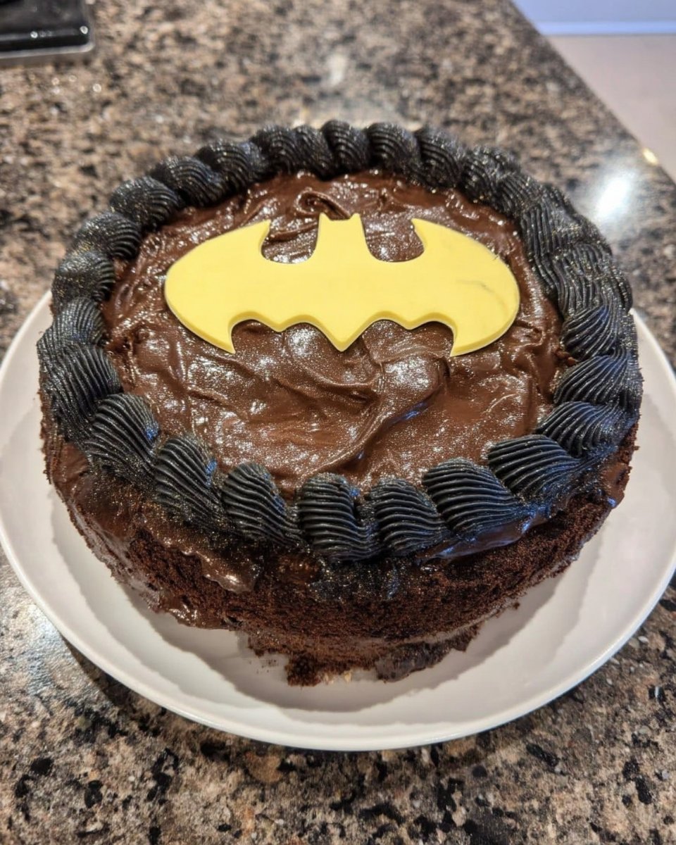 Slice of batman cake served with tea