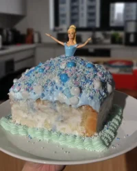 Blue ganache flowing down a princess doll cake to create a dress