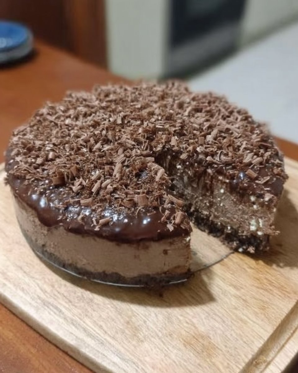 Slice of chocolate cheesecake on a plate showing ganache and crust layers