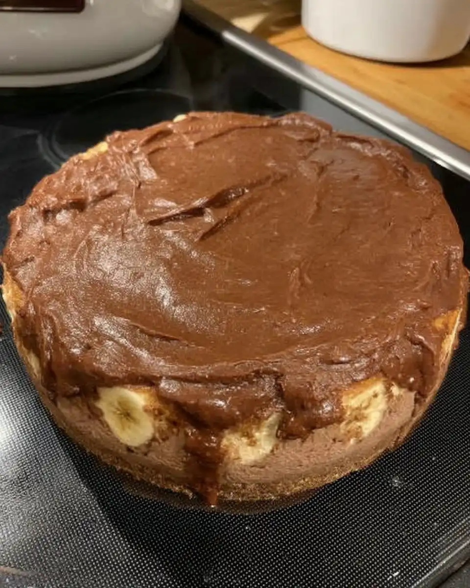 Springform pan wrapped in foil inside a roasting pan with water