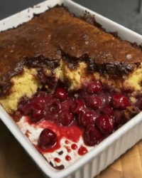 Scoop of chocolate cherry dump cake with gooey center