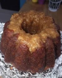Golden bundt cake slice showing dense velvety crumb texture on a white plate