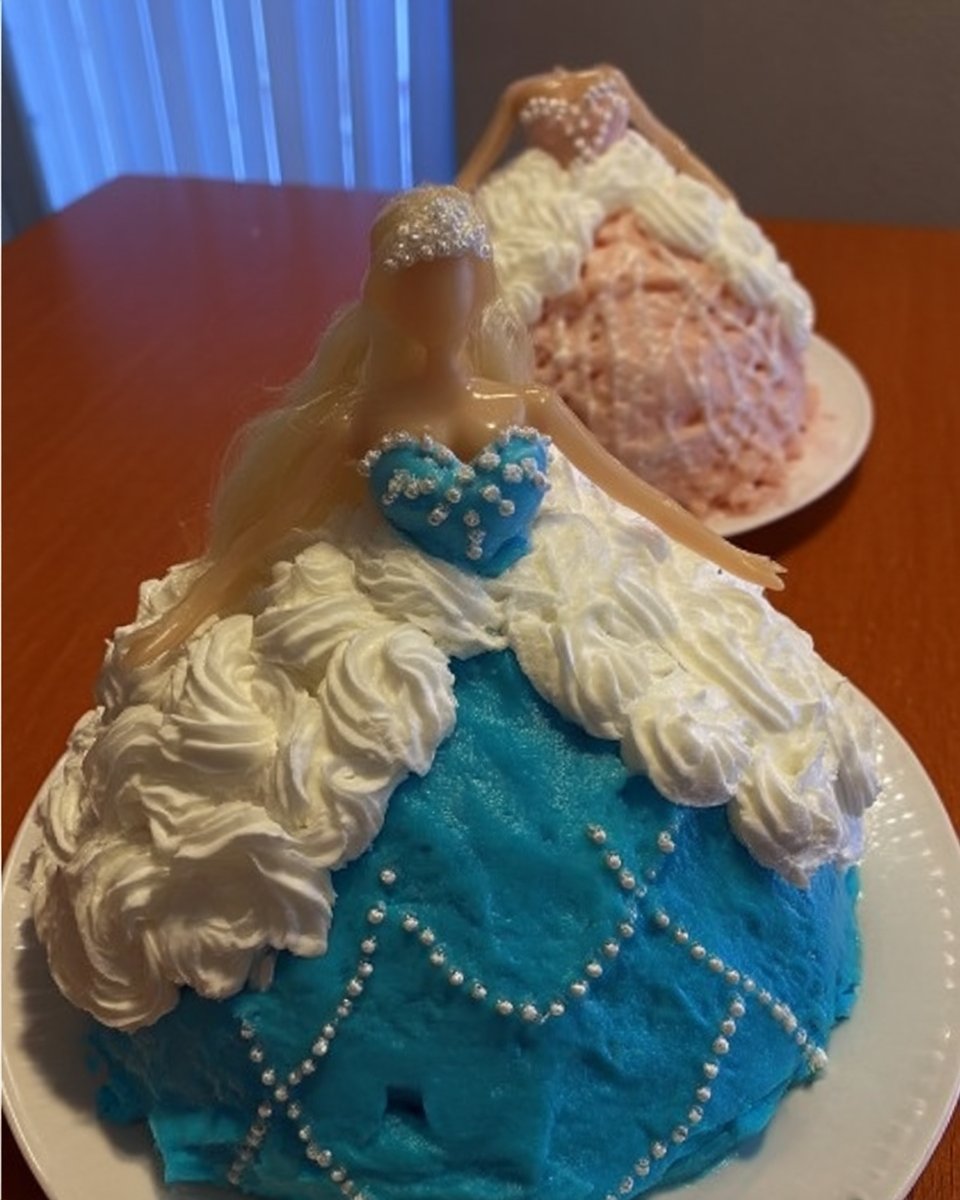 Piping pink vanilla frosting onto the cake skirt with a star tip