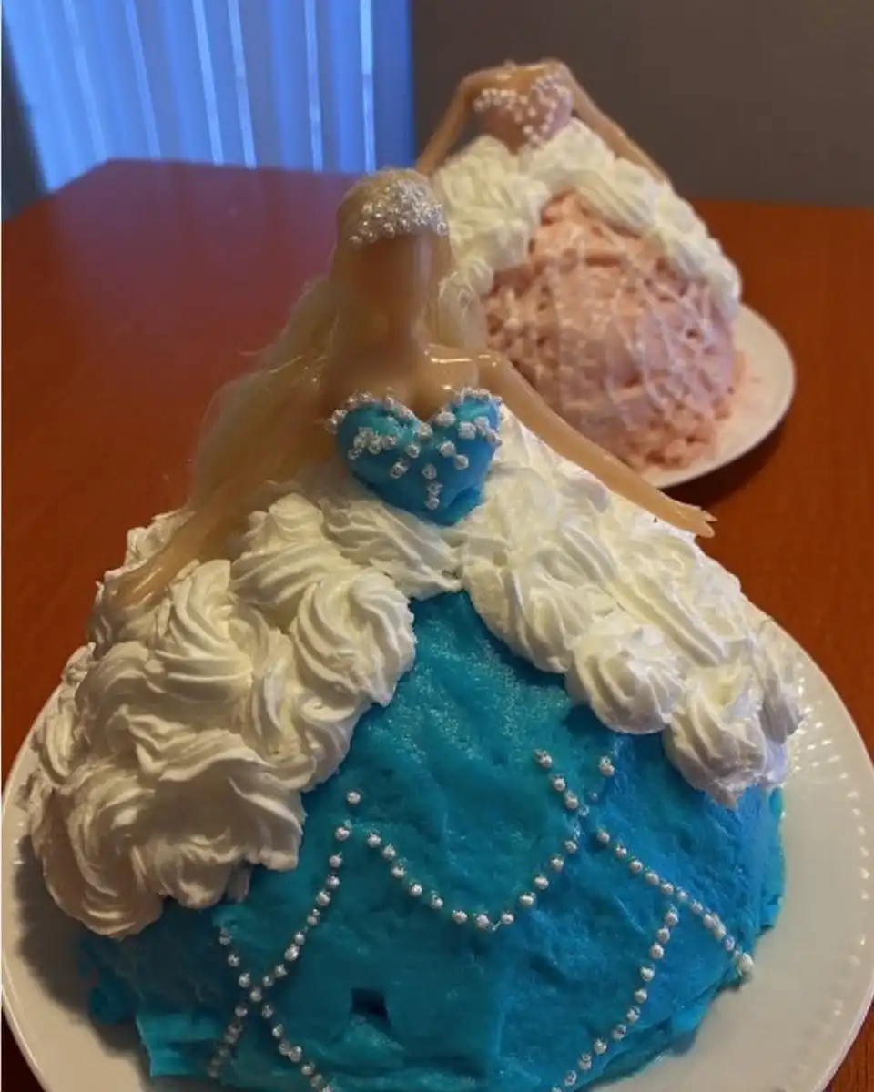 Barbie Cake 13 Piping pink vanilla frosting onto the cake skirt with a star tip