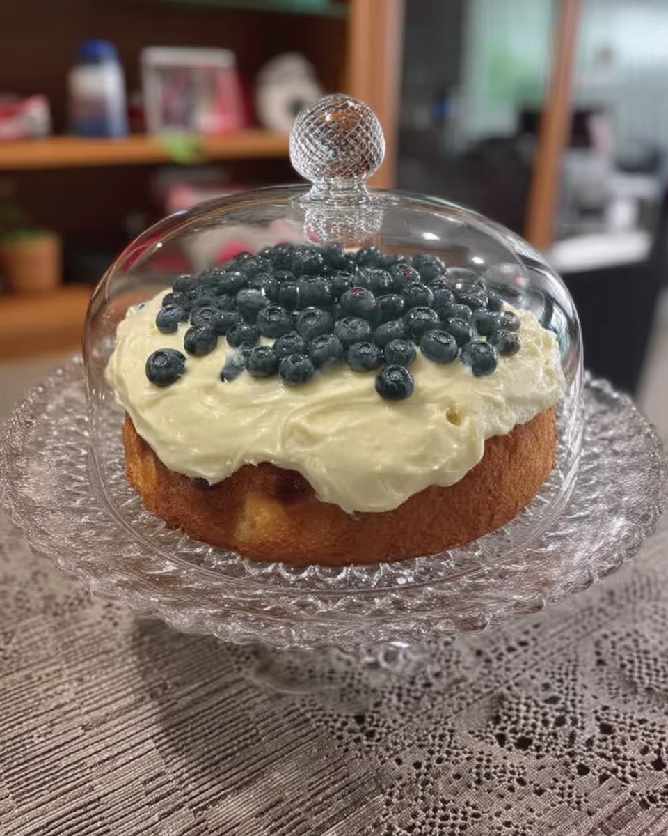 Slice of lemon blueberry cake with lemon buttercream on a white plate