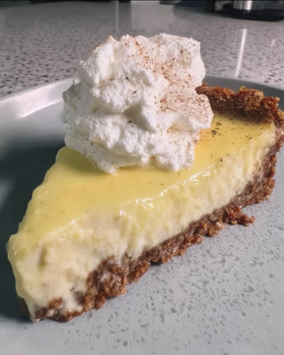 Pouring bright yellow lemon curd over the cheesecake