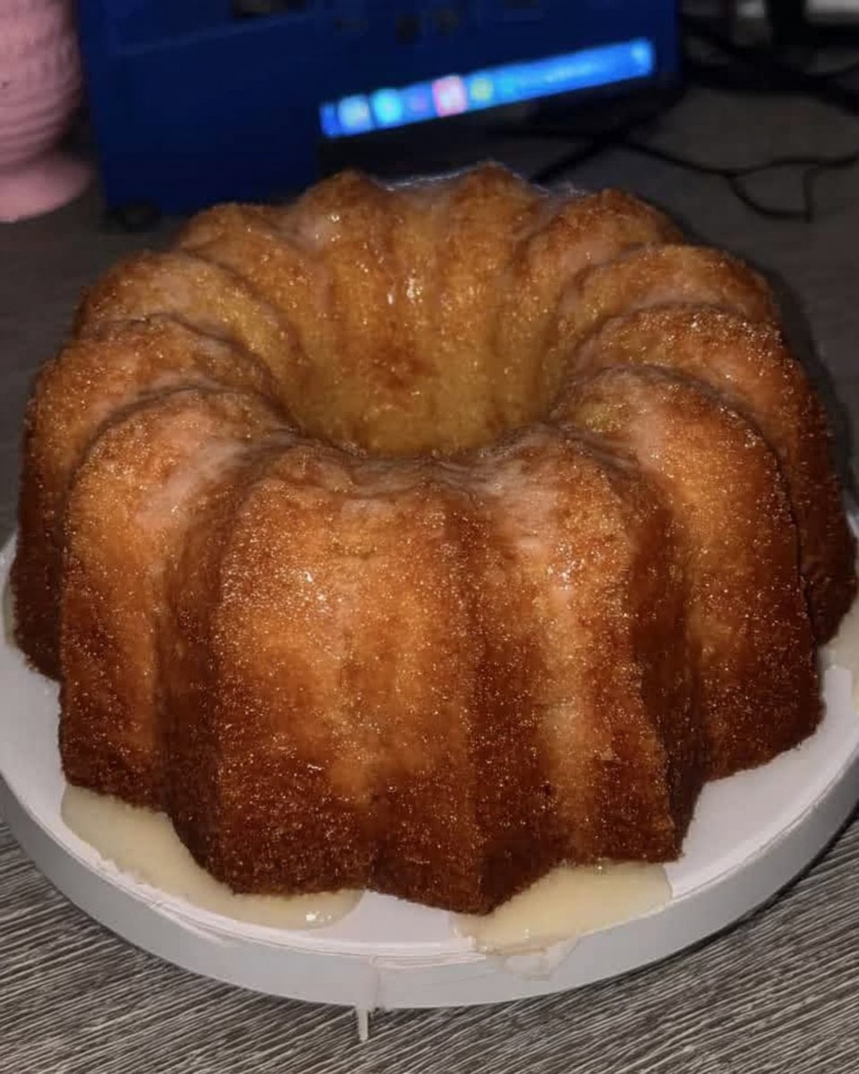 Whole lemon pound cake on a white ceramic platter