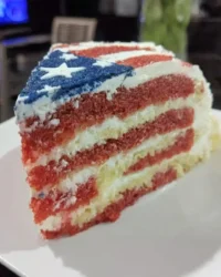 Red white and blue cake decorated with blueberries and strawberries to look like a flag