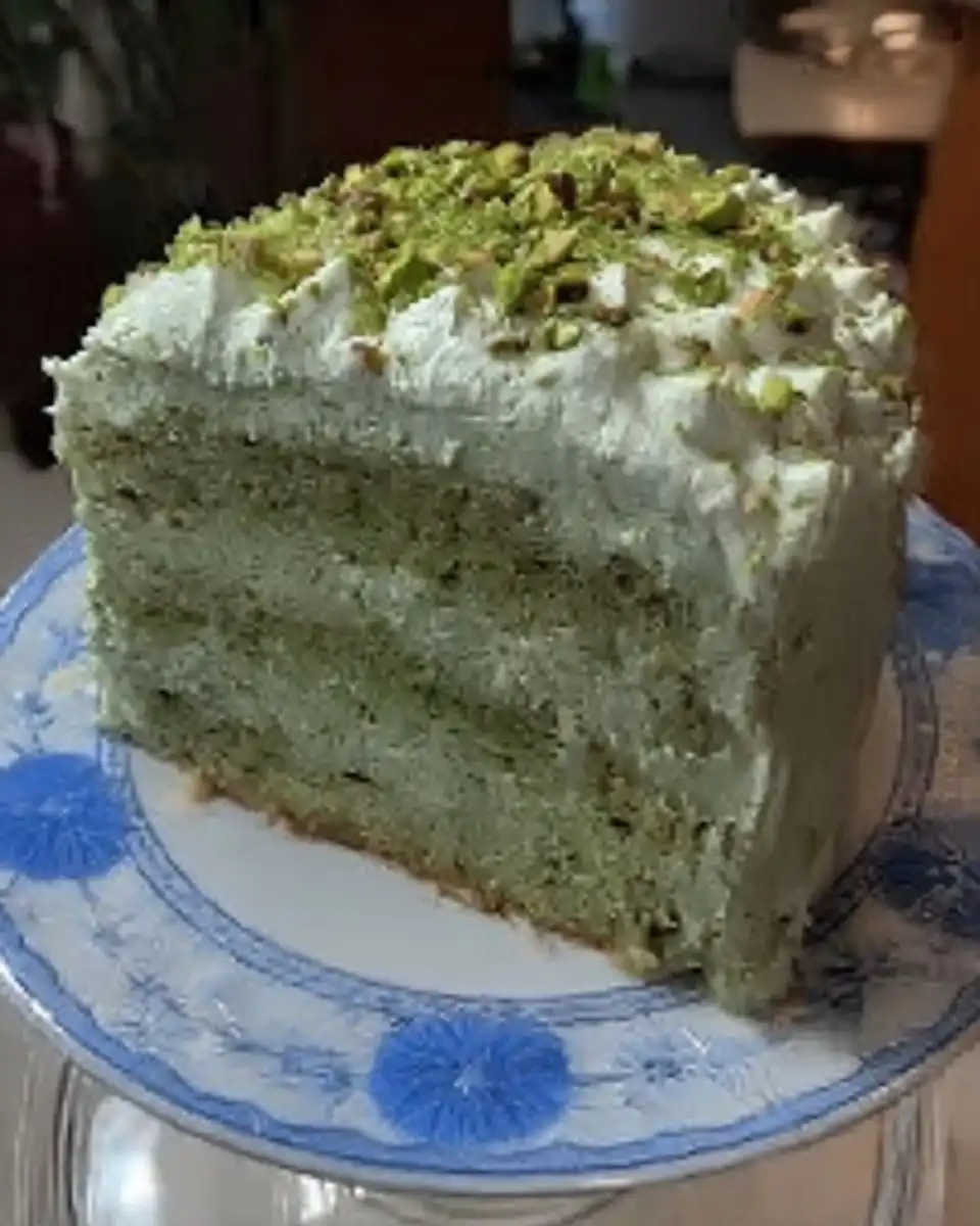 Square of watergate cake served on a vintage floral plate with a fork
