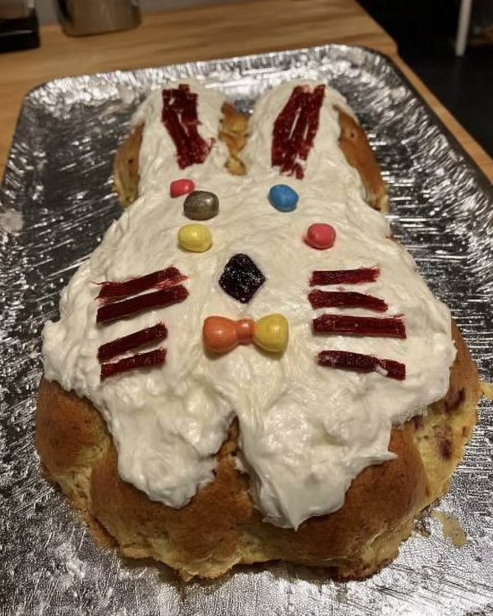 Slice of blue speckled cake on a plate showing moist vanilla layers