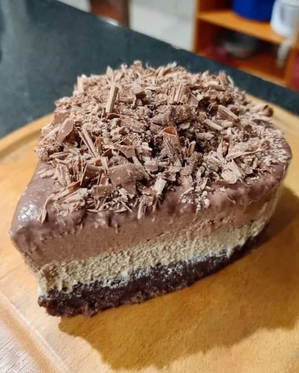 Knife slicing through chocolate cheesecake with ganache topping