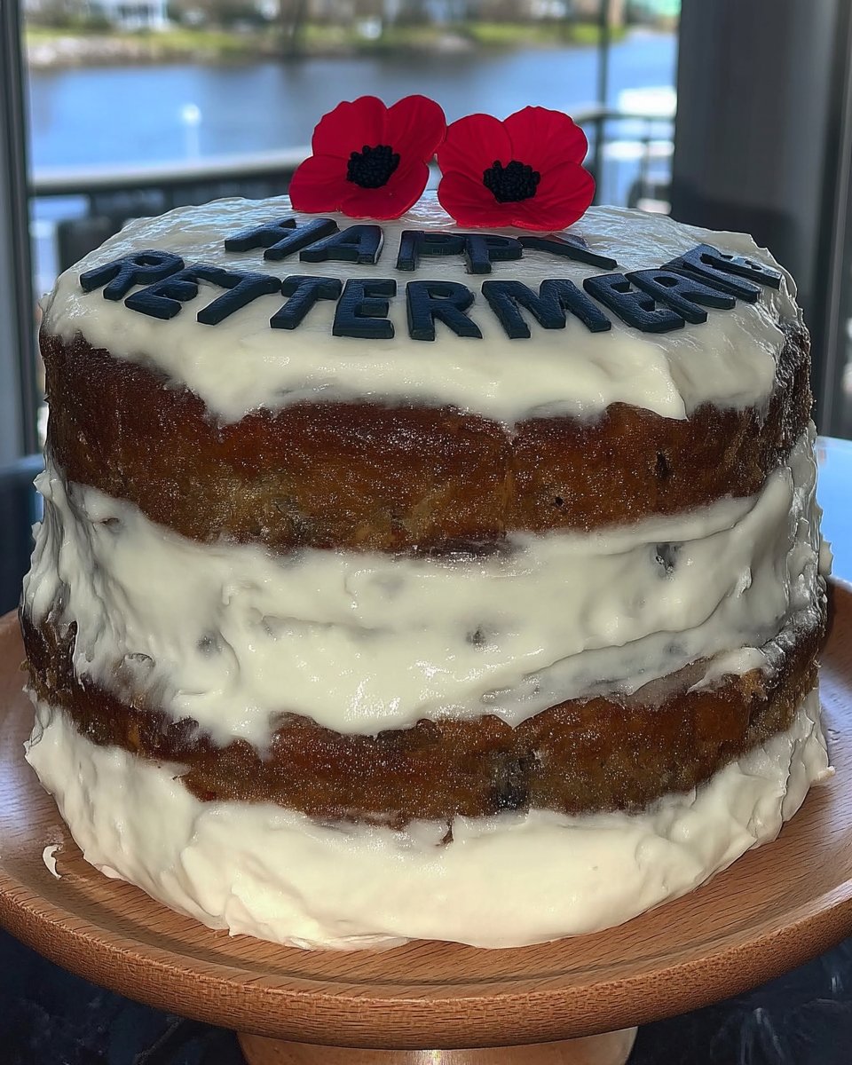 Using a smoothing tool to flatten fondant icing on a cake