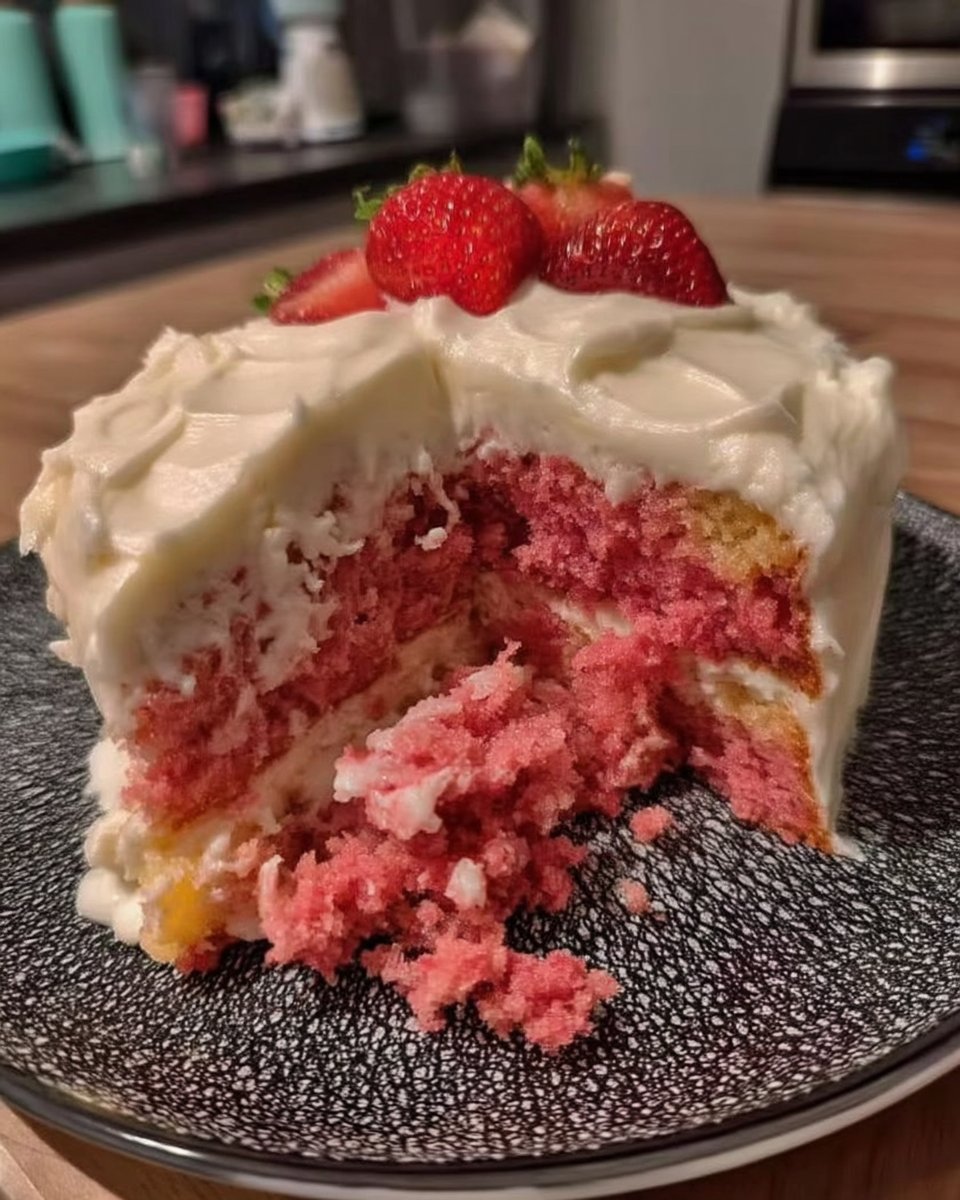 Slice of vivid pink strawberry cake on a white plate