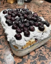 Slice of strawberry icebox cake showing layers of chocolate pudding cream and crackers