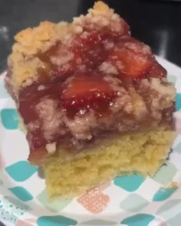 Syrup soaked strawberry rhubarb cake with holes on top