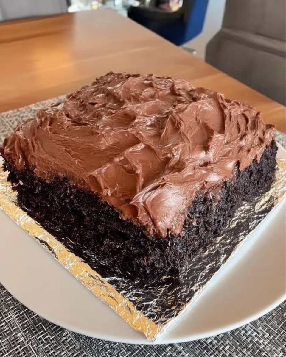 Slice of moist wacky cake on a white plate with a fork