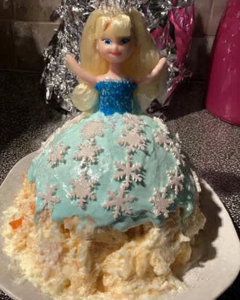 Whole green princess cake on a white cake stand