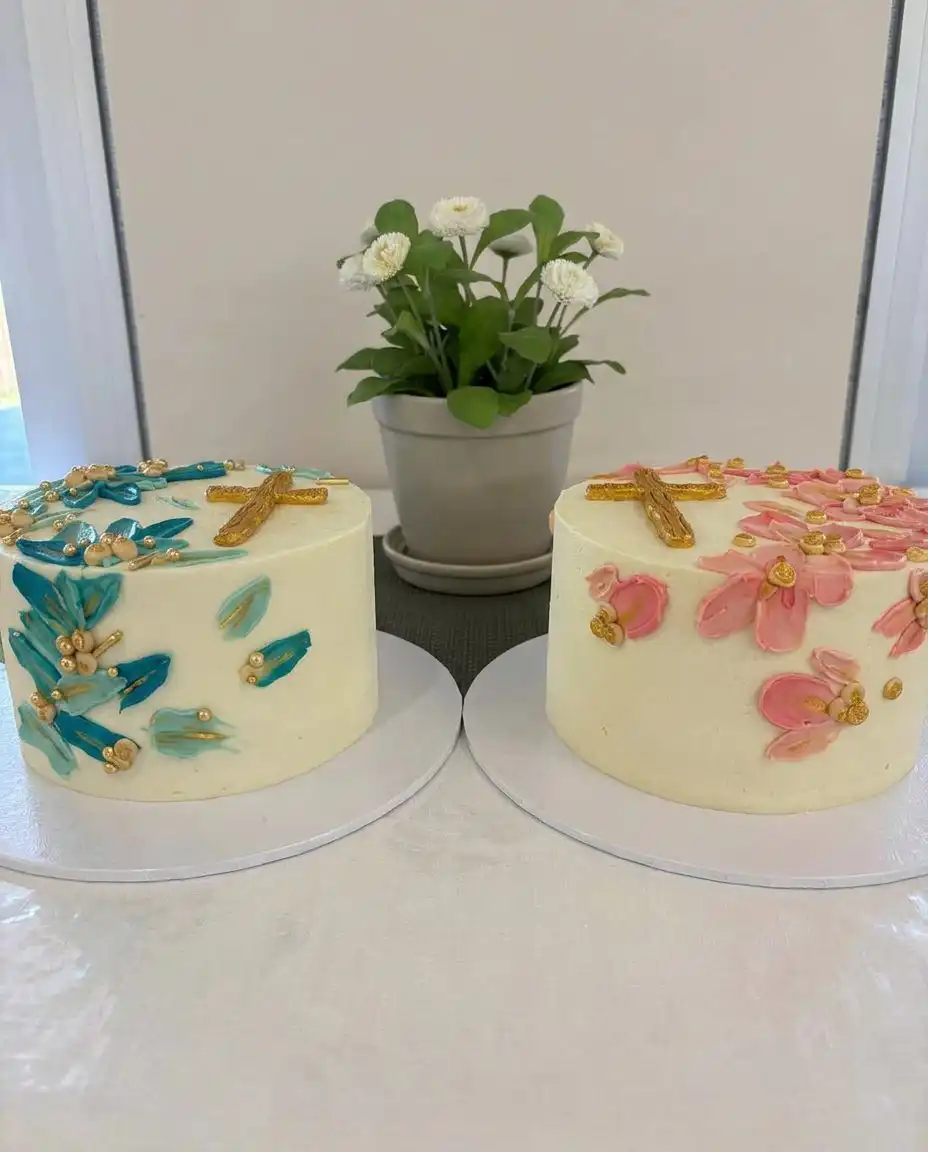 A fully decorated white baptism cake with buttercream stars and white flowers