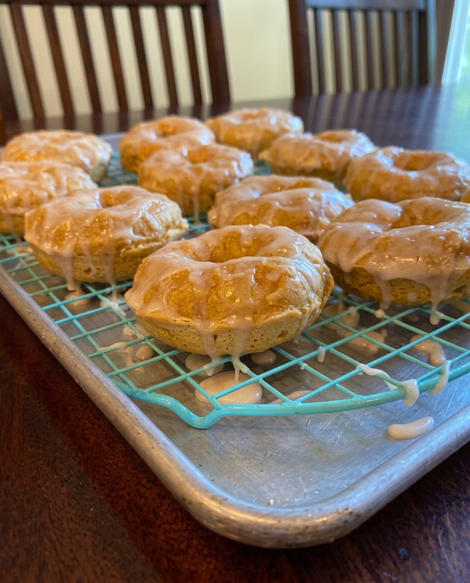 A chocolate donut cake in a Bundt shape with thick white vanilla glaze dripping down the sides.