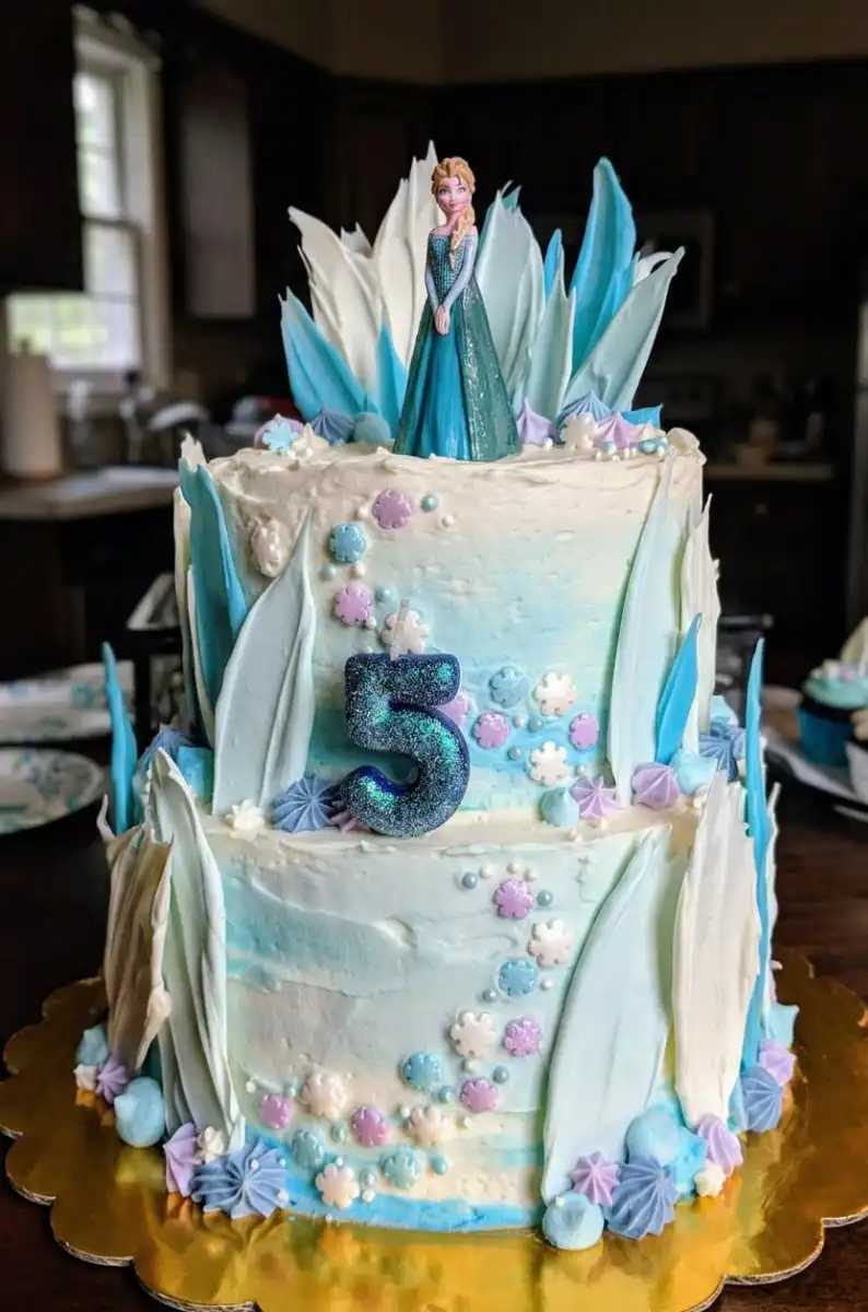 Completed tiered Frozen cake with Elsa Olaf and a sugar castle
