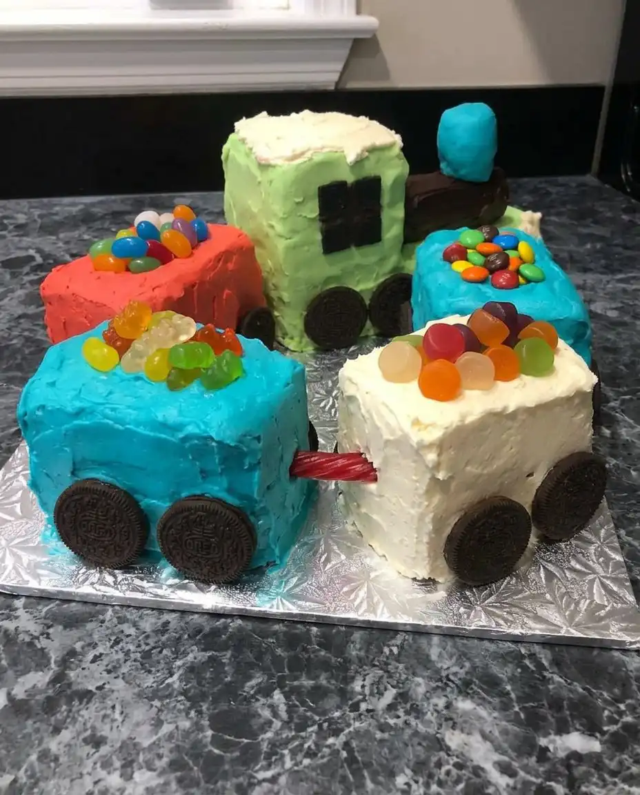 A fully decorated colorful train cake displayed on a track board