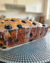 A close up shot showing the moist crumb and bursting blueberries of a lemon blueberry cake