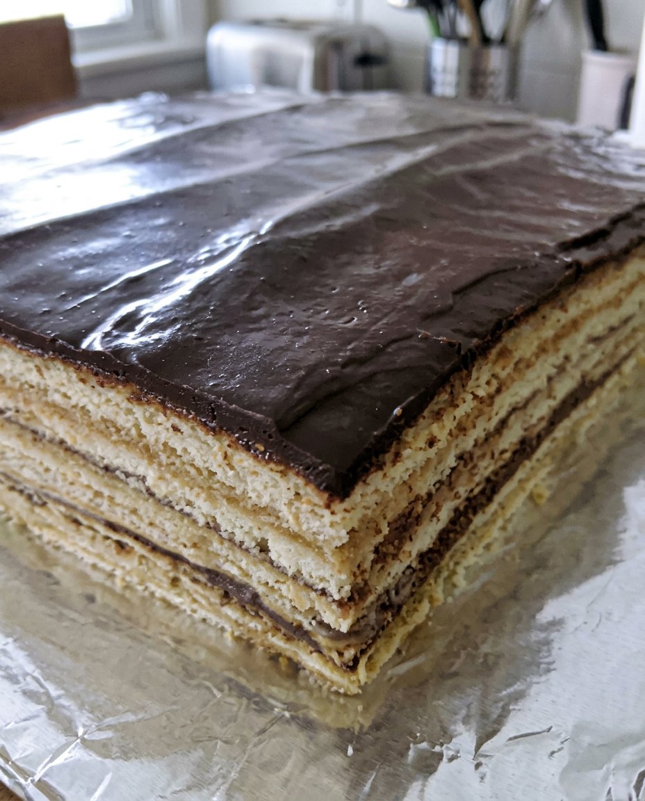 A slice of Opera Cake served next to a traditional cup of coffee
