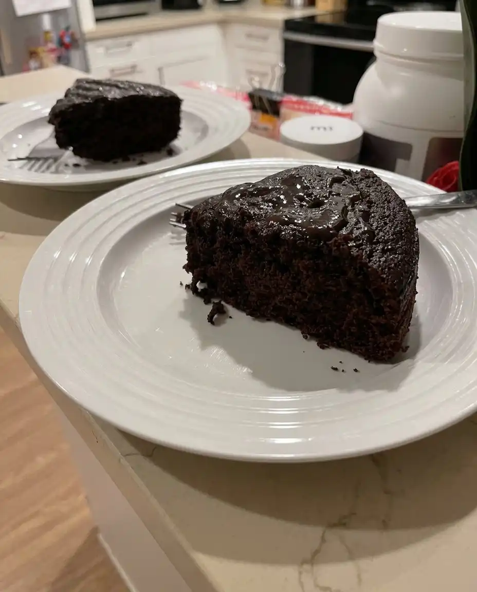 A stream of hot coffee being poured into a dark chocolate cake batter.