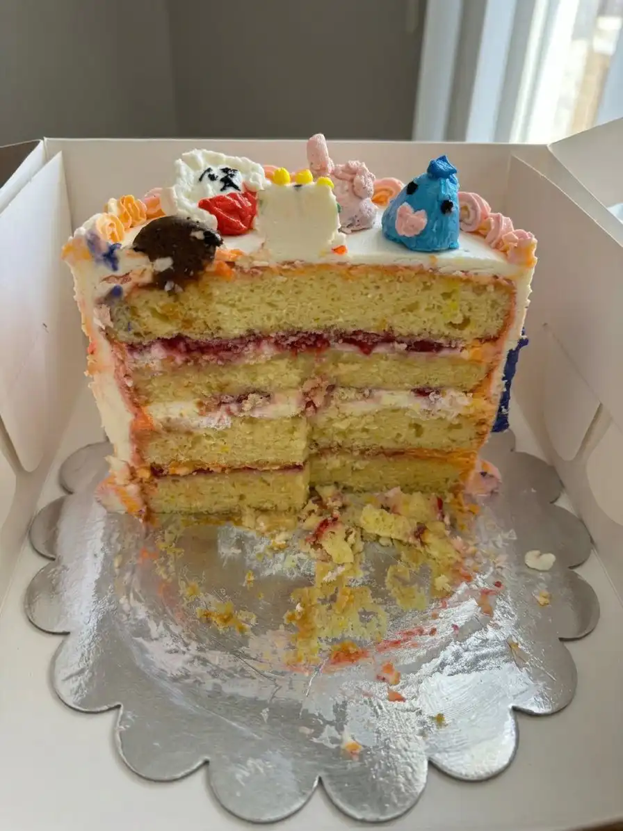 A slice of moist Bts Cake served on a plate with extra sprinkles