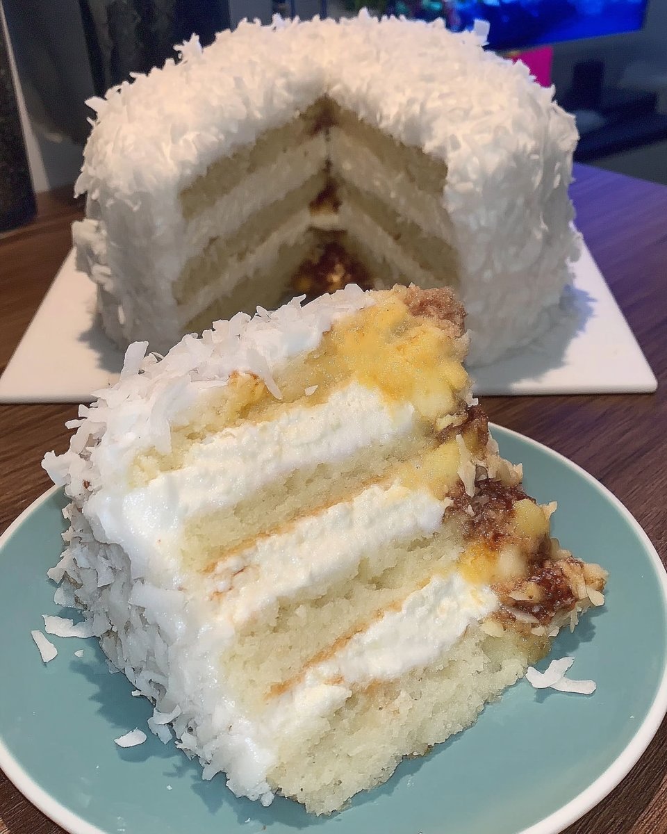 A slice of coconut cake on a white plate