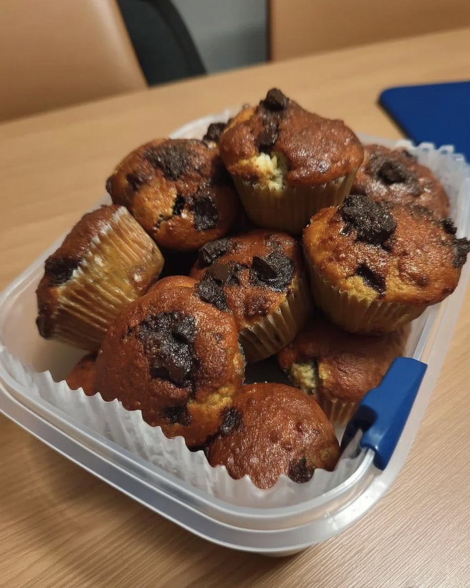 A tall three layer chocolate cake with pink strawberry buttercream and dark chocolate ganache drips