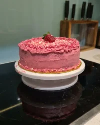 A close up shot of a strawberry yogurt cake being sliced to show the moist crumb