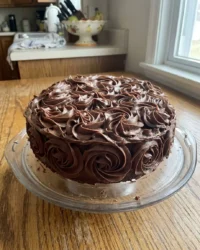 A close up of tempered dark chocolate shards on a professional cake