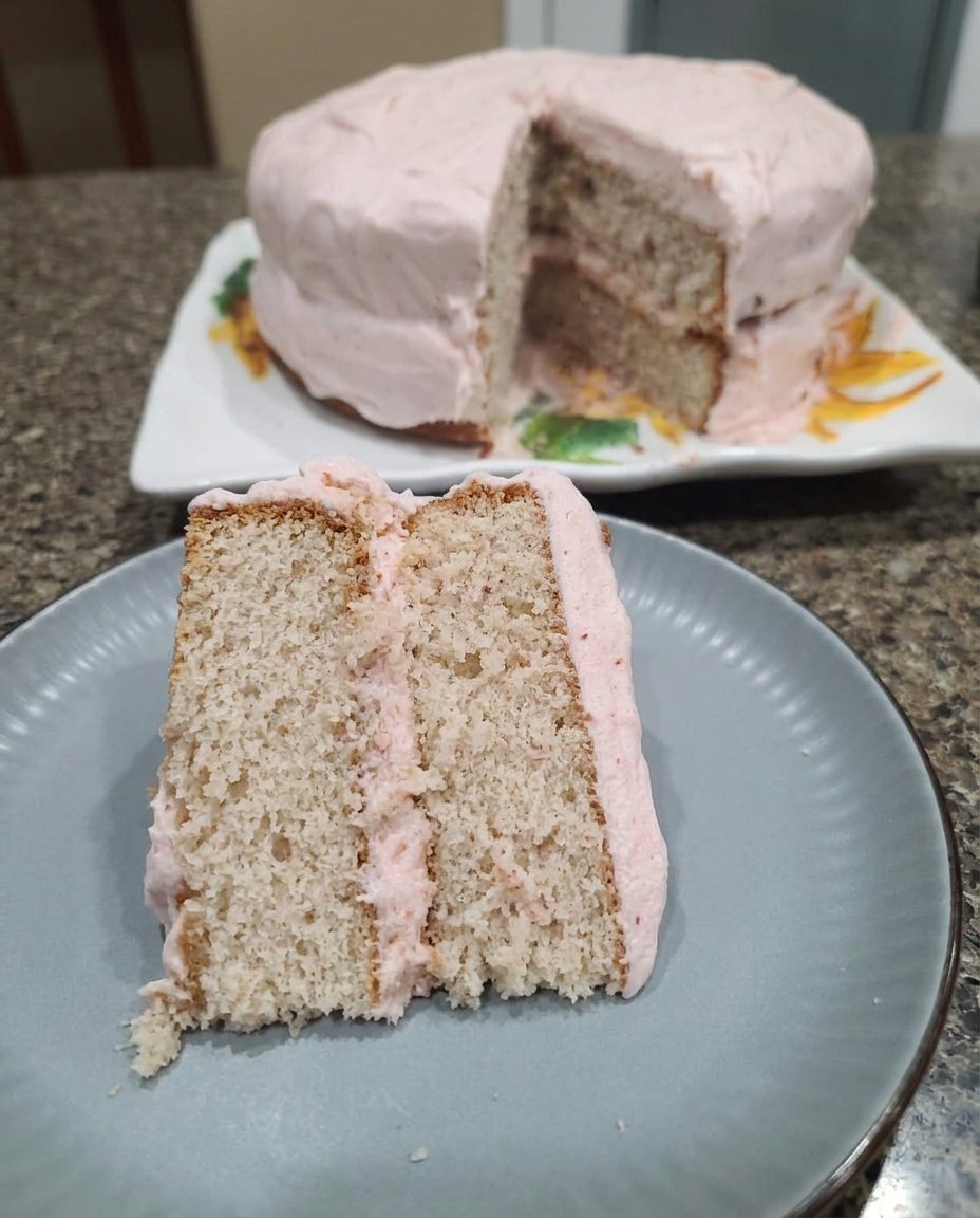 Fresh Strawberry Cake 13 Close up of smooth strawberry buttercream frosting being swirled with a spatula.