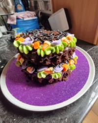 A tall vanilla Lambeth cake with pink orange and yellow buttercream ruffles and flowers