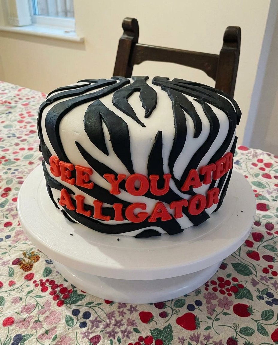 A slice of yellow cake with thick chocolate frosting on a vintage floral plate