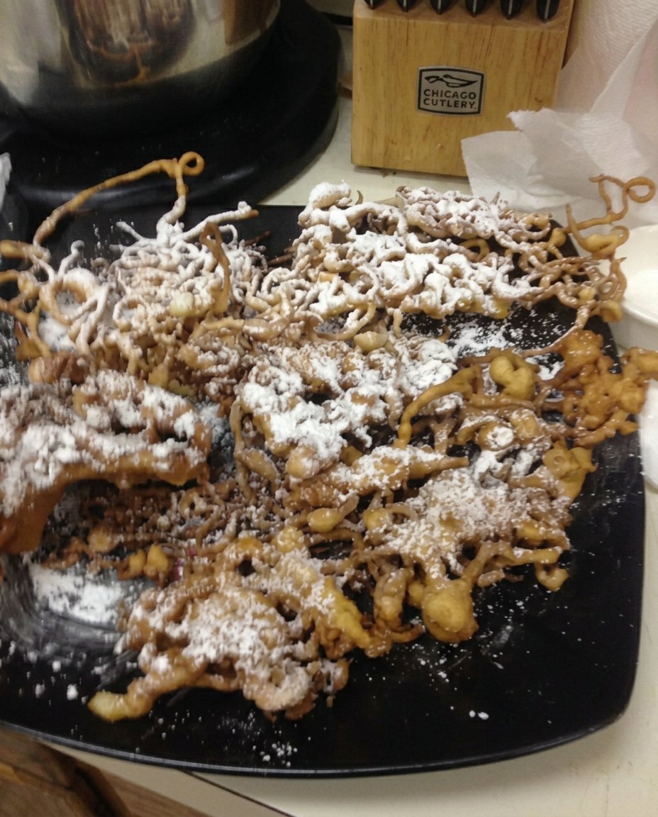 Funnel cake batter swirling in hot oil in a saucepan