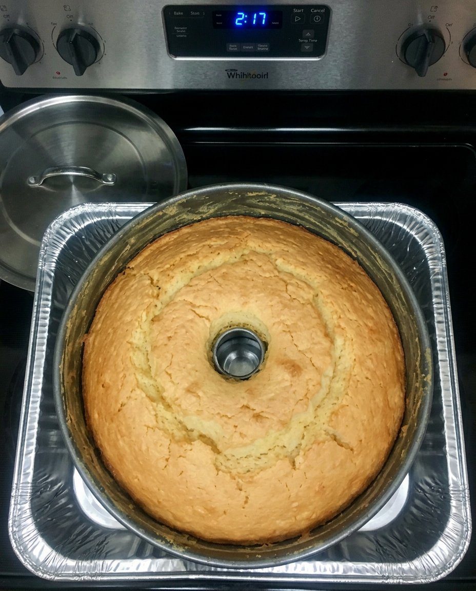 A clean slice of 7 Up Cake on a white plate with a drizzle of glaze.