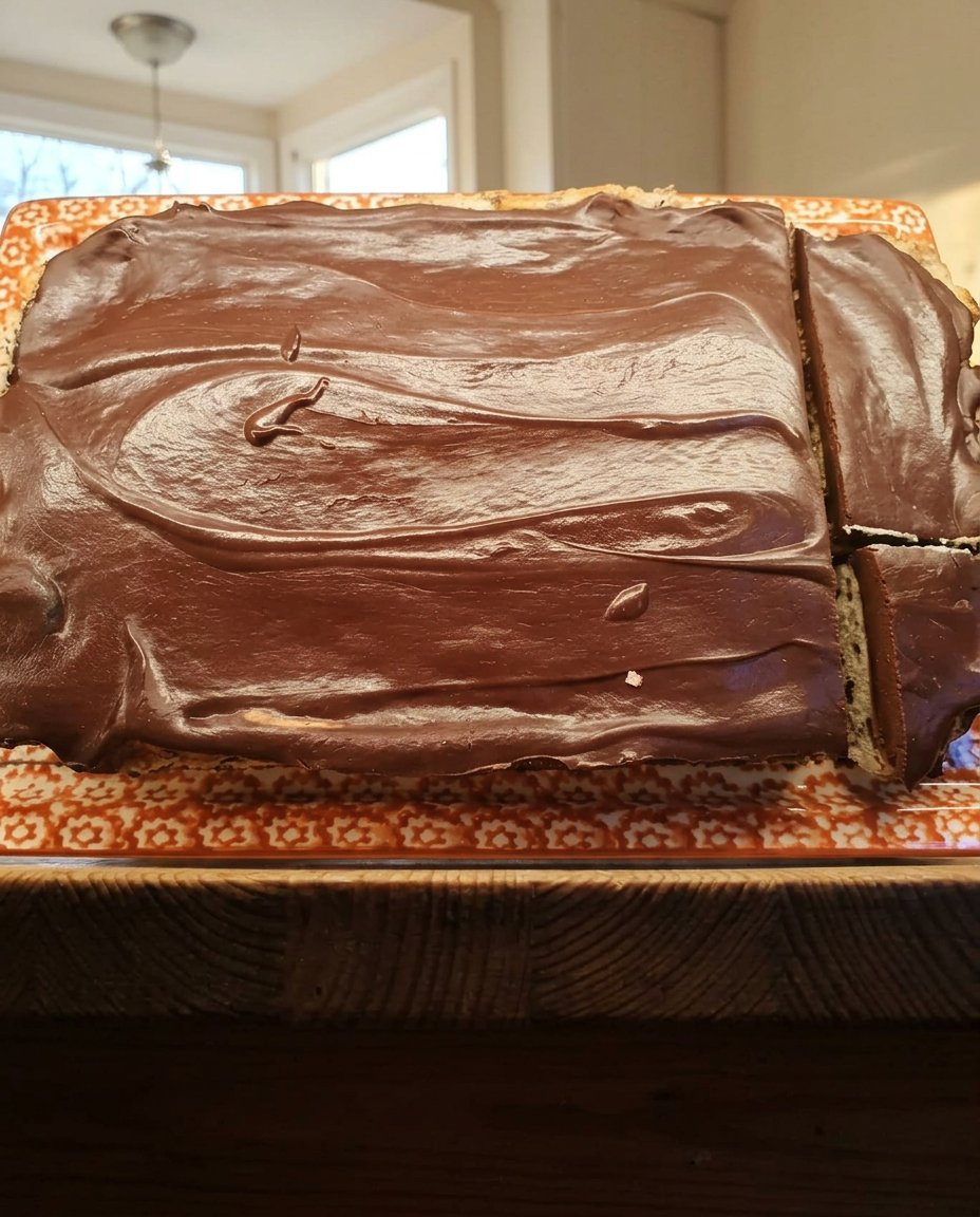 A single slice of moist chocolate ganache cake with glossy topping