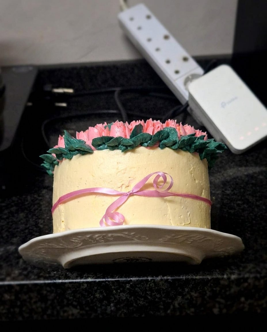 A beautiful one-layer cake topped with ivory and purple buttercream tulips and pearls.