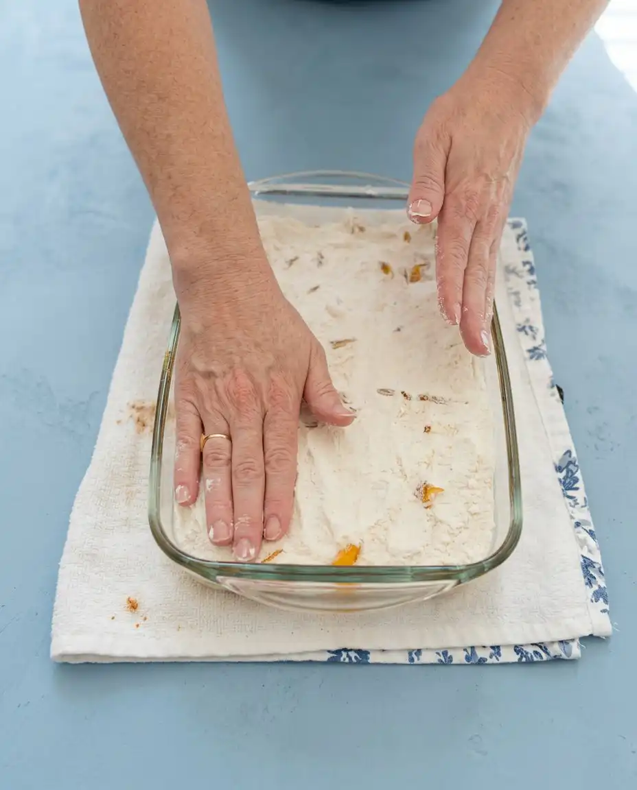 Canned peaches in heavy syrup being poured into a baking dish for Canned Peach Dump Cake with Yellow Cake Mix.