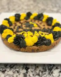 A close up of a slice of chewy cookie cake showing a soft center and chocolate chips