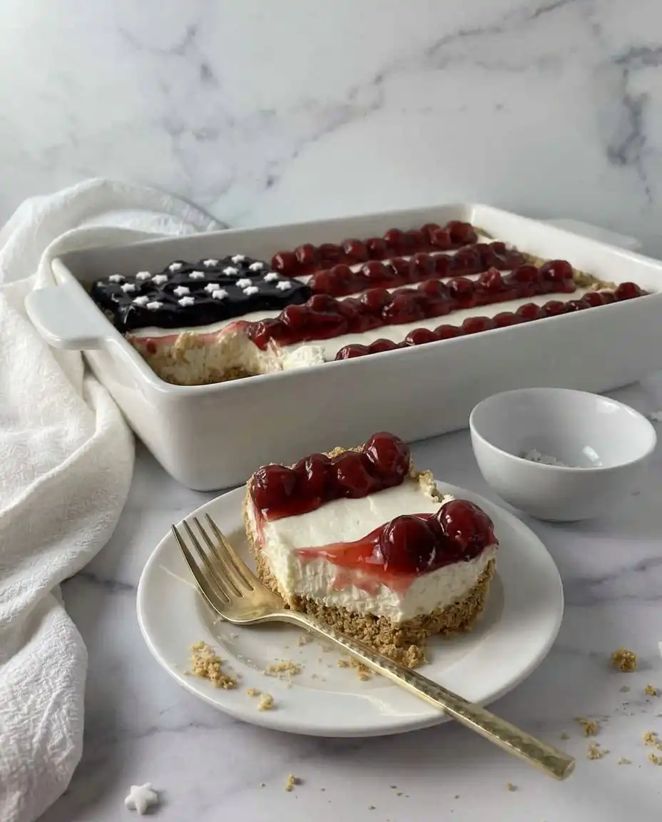 Fully decorated American flag cheesecake with blueberry stars and cherry stripes ready to slice