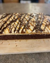 A close up of a chocolate cake with evenly spaced holes for the caramel soak