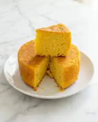 A beautiful slice of Classic Mango Sponge Cake showing the airy layers and fresh fruit.