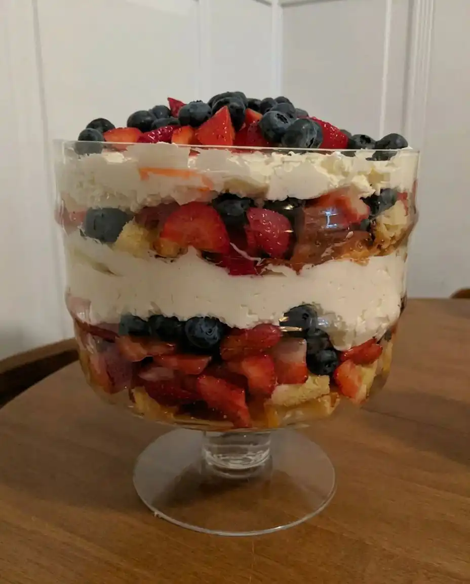 A cleanly scooped portion of the layered berry and cake trifle in a glass dessert bowl.