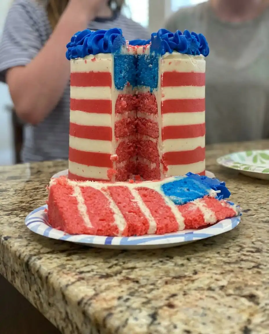 The American Flag Cake served on a white stand with a cup of coffee