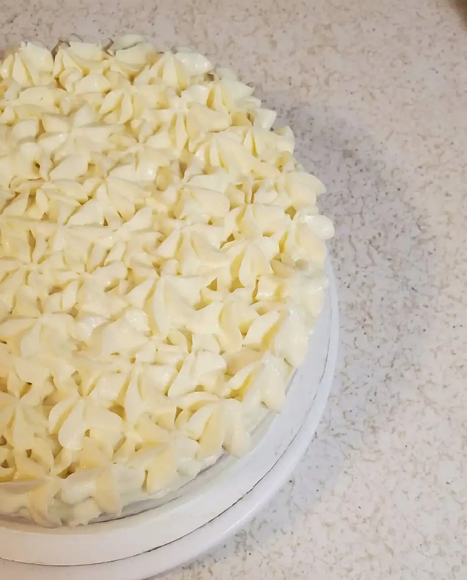 A silicone spatula folding egg whites into a lemon cake batter.