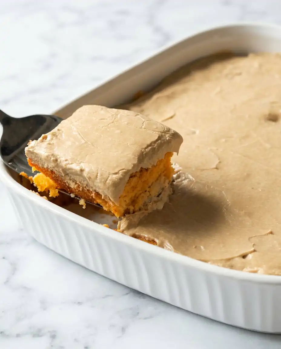 A stainless steel pot of brown sugar frosting cooling in a bowl of ice water.