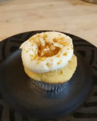 A close up of a peach and honey cheesecake cupcake with a glossy fruit topping